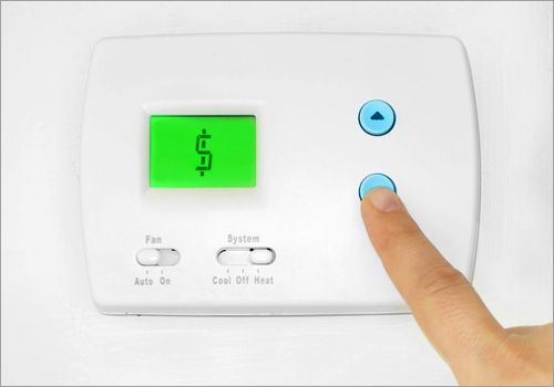 finger pressing thermostat button