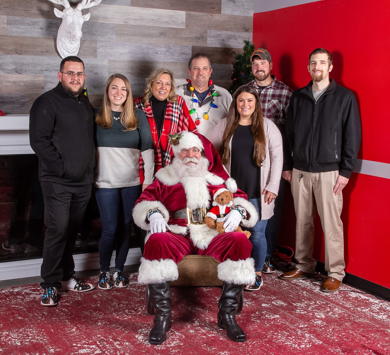 Group of SS team members posing with Santa Claus in a festive holiday setting