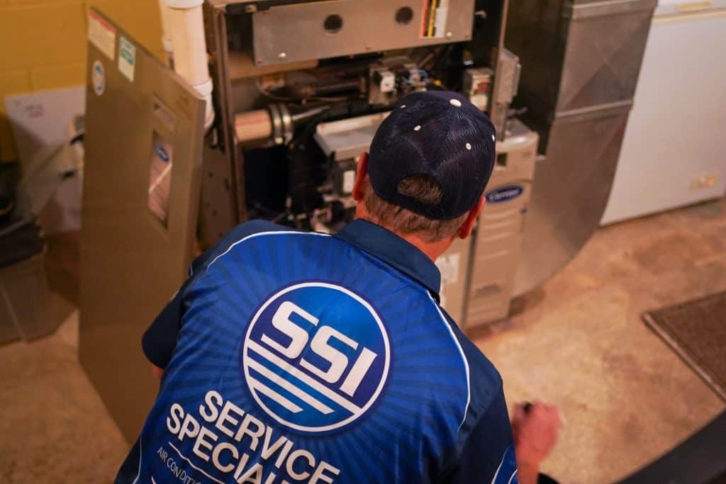 HVAC technician inspecting residential furnace system