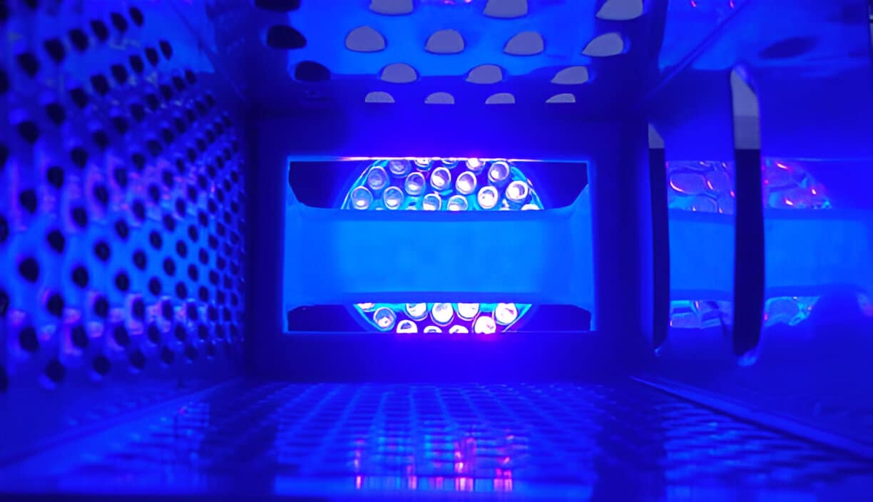 Close-up view of an illuminated UV air purifier inside an HVAC system