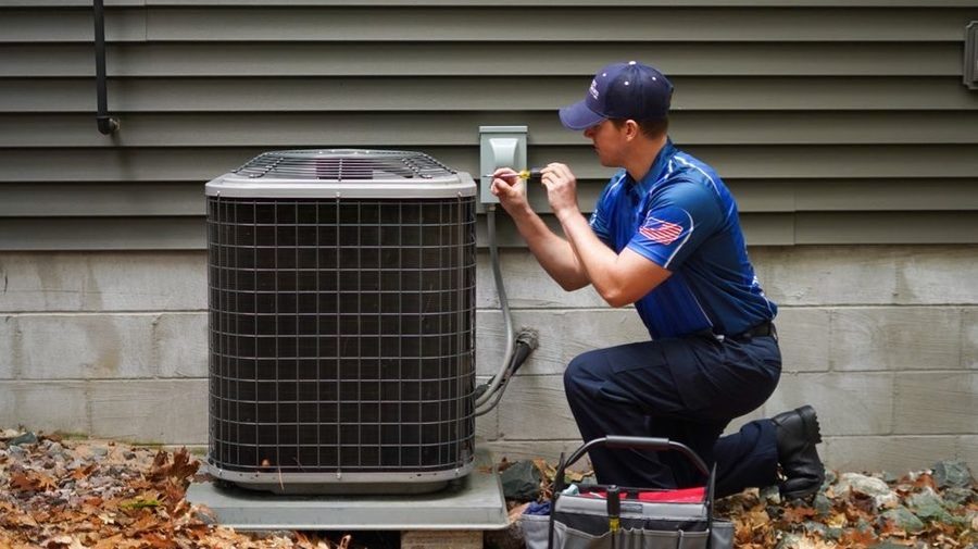 Service Specialties plumber working on air conditioning.