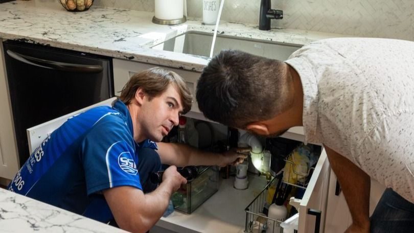 Service Specialties technician showing a customer a drain in need of cleaning