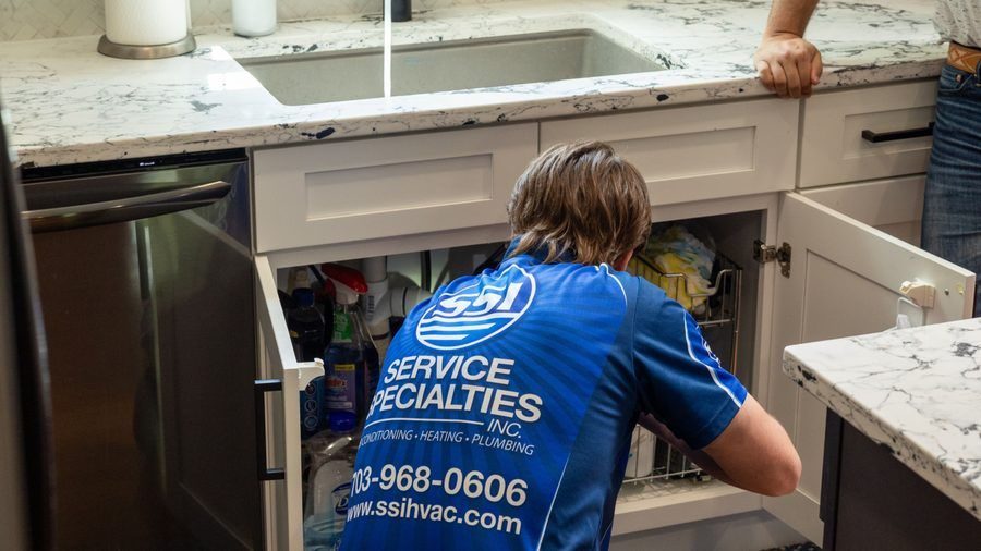 Plumber installing garbage disposal.