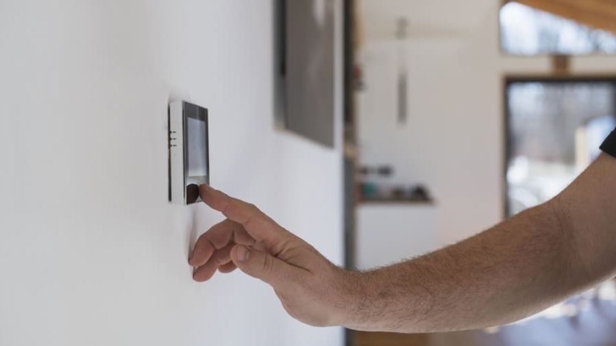 HVAC tech setting up smart thermostat.
